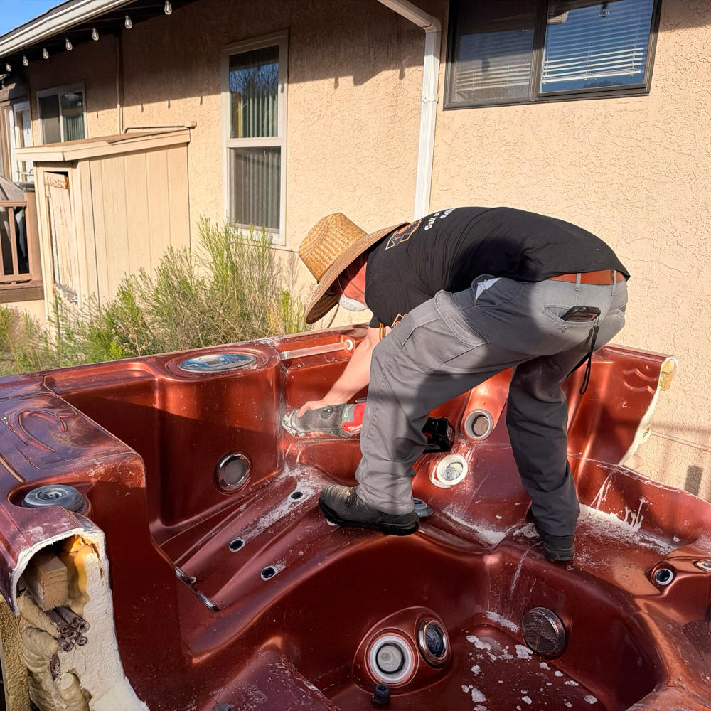 Backyard hot tub removal with reciprocating saw cutting spa into pieces